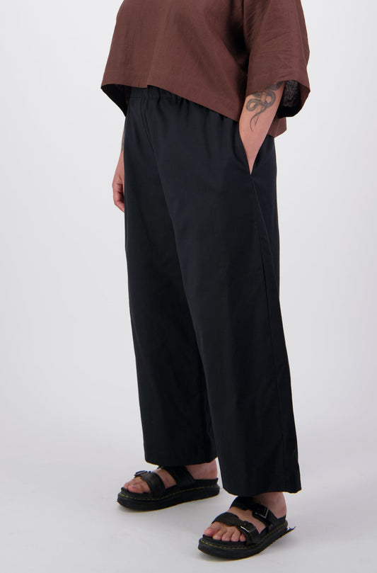 Arlena wearing black twill pants with her hand in the side seam pocket