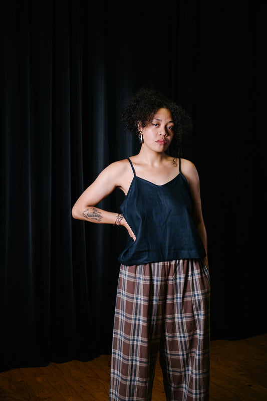 Pacific island artist, Nita wearing navy linen singlet with brown plaid pants in south Auckland theatre