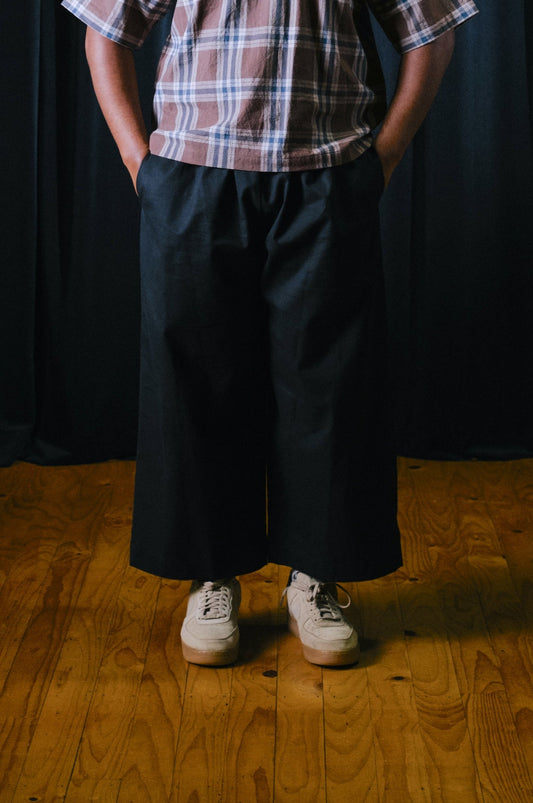 Pacific island artist keciano wearing black twill wide leg pants standing in a theatre in south auckland