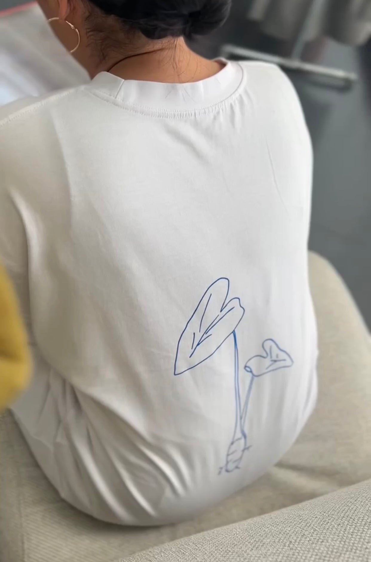 womans back wearing white tee with Taro drawing print